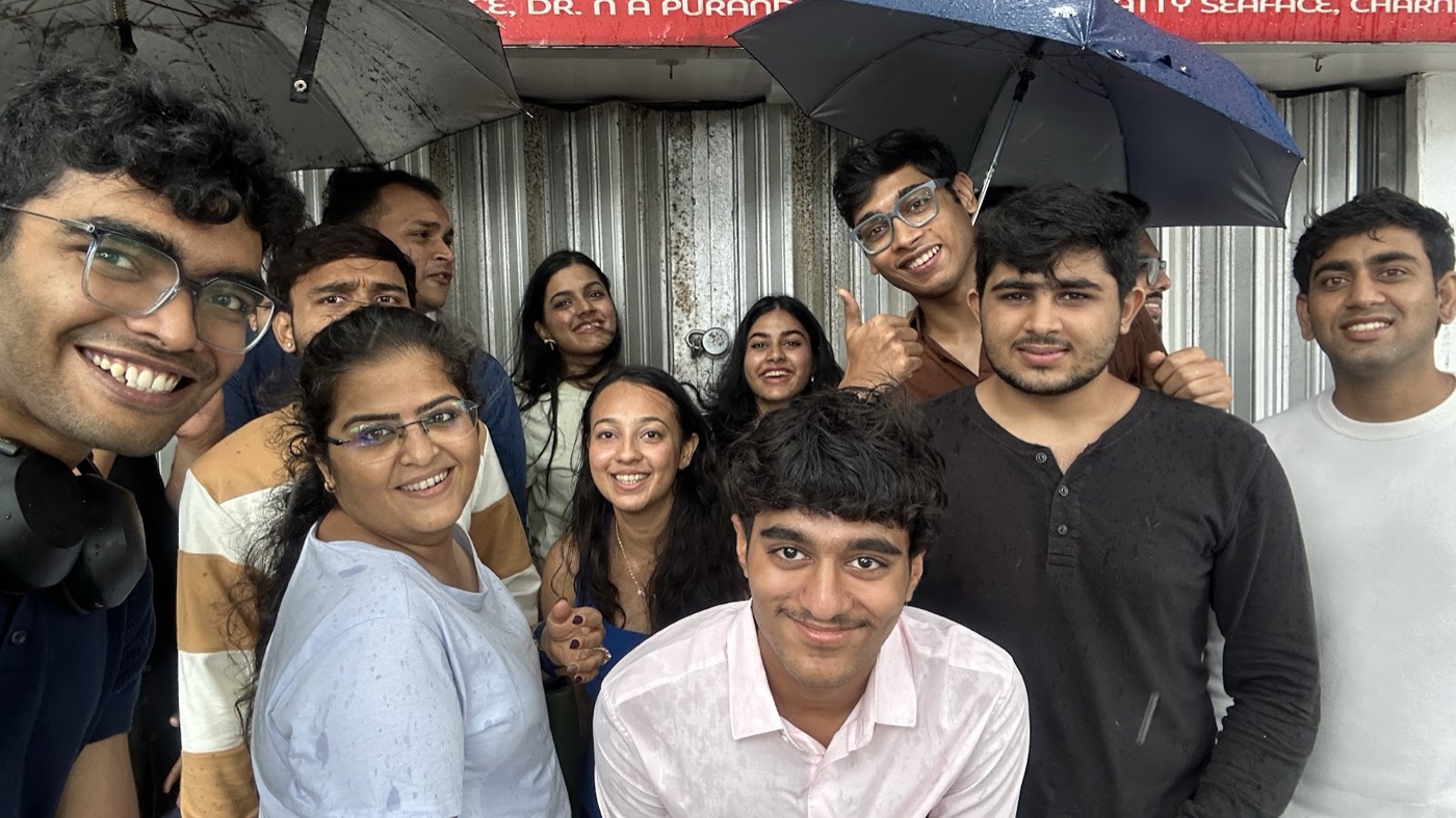 the whole crew crammed under umbrellas